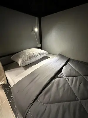 a large bed with a pillow on top of it at Atlas Hostel Khaosan in Bangkok