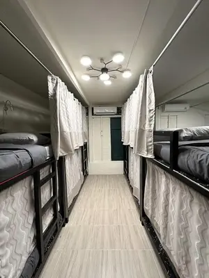 an empty trailer with two beds and a ceiling fan at Atlas Hostel Khaosan in Bangkok