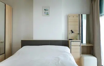 a bedroom with a white bed and a window at Bangkok Feliz Sukumvit69 in Bangkok
