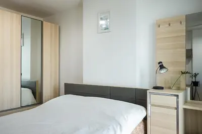 a bedroom with a white bed and a mirror at Bangkok Feliz Sukumvit69 in Bangkok