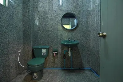 a bathroom with a green toilet and a sink at GO INN The Grand Palace I โกอินน์ พระบรมมหาราชวัง สถานี MRT สามยอด in Bangkok