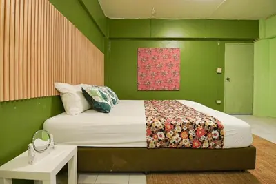 a green bedroom with a bed and a table at XX GO INN The Grand Palace I โกอินน์ พระบรมมหาราชวัง in Bangkok