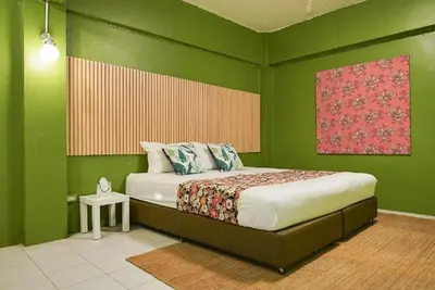a bedroom with green walls with a bed and a table at XX GO INN The Grand Palace I โกอินน์ พระบรมมหาราชวัง in Bangkok