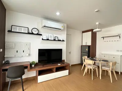 a living room with a dining table and a television at 6th Avenue Sukhumvit BKK 302 BTS Asoke & Nana MRT Sukhumvit in Bangkok