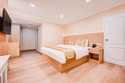 a bedroom with a large bed and a flat screen tv at Palette The Travellers Hotel Bangkok in Bangkok