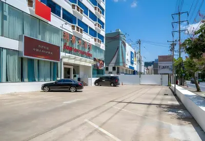 two cars parked in a parking lot in front of a building at Palette The Travellers Hotel Bangkok in Bangkok