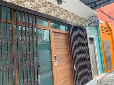 a building with a wooden door and a sign on it at GO INN The Giant Swing เสาชิงช้า in Bangkok