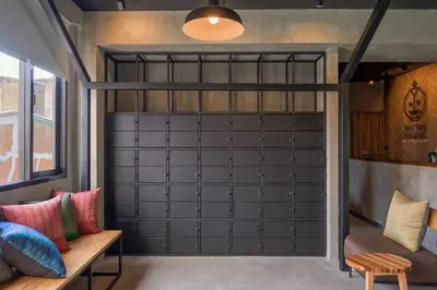 a garage with a black garage door in a room at Fellows House in Bangkok