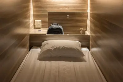 a small bed in a small room with a pillow at Fellows House in Bangkok