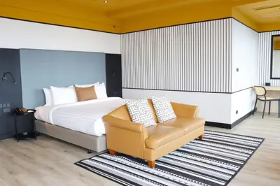 a bedroom with a bed and a chair at The Quarter Saphankhwai by UHG in Bangkok