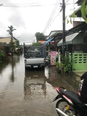 a truck is parked in a flooded street at ประเทศไทย in Ban Bang Krang