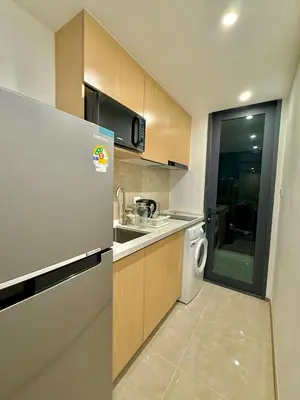 a kitchen with a refrigerator and a washing machine at Regal 40 Srinakarin Apartment in Bangkok