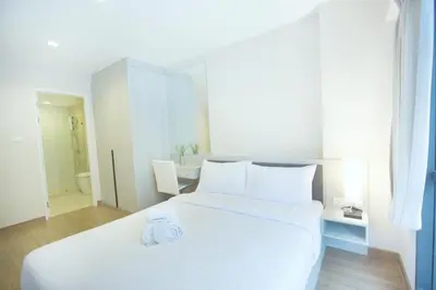 a large white bed in a room with a bathroom at Park 19 Hotel in Bangkok