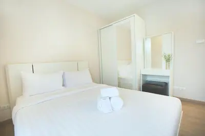 a bedroom with a white bed with two towels on it at Park 19 Hotel in Bangkok