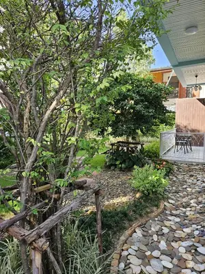a garden with a wooden fence and a bench at Dusita Residence in Bangkok