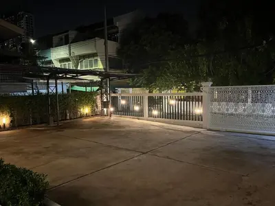 a white fence with lights on it at night at Dusita Residence in Bangkok