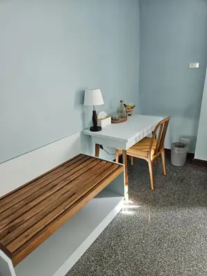 a table and a bench in a room with a lamp at Dusita Residence in Bangkok