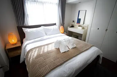 a bedroom with a bed with two towels on it at Spacious 4-Bedroom Oasis in the Heart of Sukhumvit in Bangkok