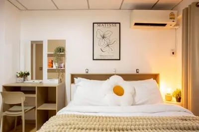 a bedroom with a bed with a stuffed animal on it at Cosy Lodge MRT Phra Ram 9 in Bangkok