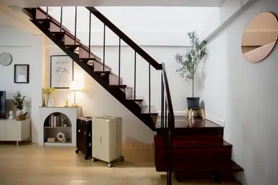 a staircase in a living room with a stair case at Cosy Lodge MRT Phra Ram 9 in Bangkok