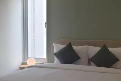 a bedroom with a bed with pillows and a window at Squirrel House in Bang Rak