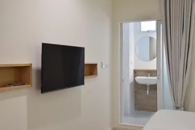 a flat screen tv hanging on a wall in a bathroom at Squirrel House in Bang Rak