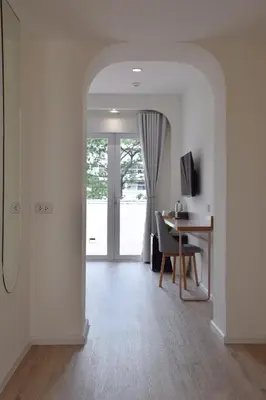 a white room with a desk and a table with a computer at Squirrel House in Bang Rak