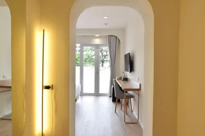 a hallway with a room with a desk and a door at Squirrel House in Bang Rak