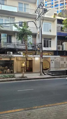 a building on a city street with a palm tree at Squirrel House in Bang Rak