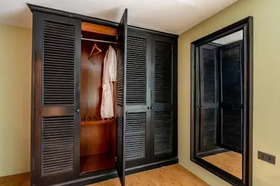 a walk in closet with black shutter doors at PEONY Rustic Apartment Sukhumvit, Nana BTS in Bangkok