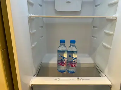 two bottles of water sitting inside of a refrigerator at PEONY Rustic Apartment Sukhumvit, Nana BTS in Bangkok