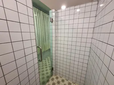 a bathroom with a shower with white tiled walls at RB9 Oliver's House in Kaset in Ban Yang
