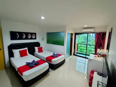 a bedroom with two beds and a large window at Pak-D Resort in Bangkok