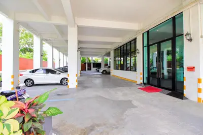 a building with cars parked in a parking lot at Pak-D Resort in Bangkok