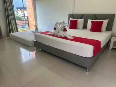 two stuffed rabbits sitting on a bed in a bedroom at Pak-D Resort in Bangkok