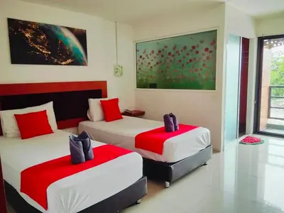 two beds in a room with red and white at Pak-D Resort in Bangkok