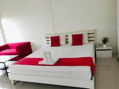 a bedroom with a large white bed with red pillows at Pak-D Resort in Bangkok