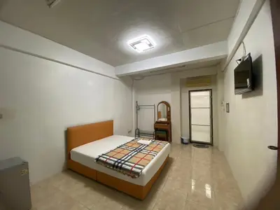 a bedroom with a bed and a television in it at PTT Mansion ปทิตา แมนชั่น in Ban Zong Katiam