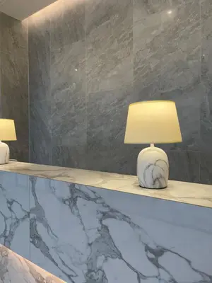 two lamps sitting on a counter with a marble wall at K Maison Boutique Hotel in Bangkok