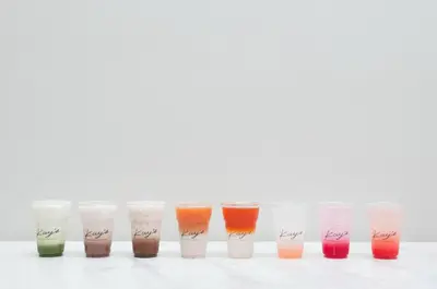 a row of different colored liquids in glass cups at K Maison Boutique Hotel in Bangkok