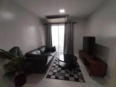 a living room with a couch and a television at MeStyle Sukhumvit Banana มีสไตล์สุขุมวิท บางนา in Bangna