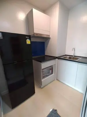 a kitchen with a black refrigerator and a sink at MeStyle Sukhumvit Banana มีสไตล์สุขุมวิท บางนา in Bangna