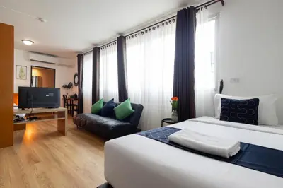 a hotel room with a bed and a couch at Nature Boutique Hotel Ratchayothin in Bangkok
