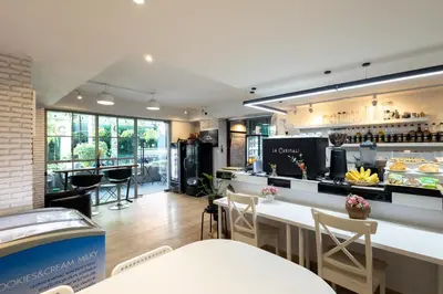 a restaurant with a bar with chairs and a counter at Nature Boutique Hotel Ratchayothin in Bangkok