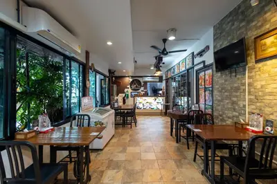 a restaurant with tables and chairs in a room at Nature Boutique Hotel Ratchayothin in Bangkok