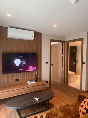 a living room with a flat screen tv on a wall at Spacious Bedroom- 2 mins from Train Station in Bangkok