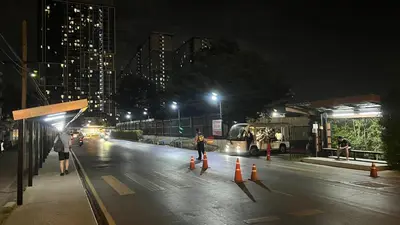 a person is walking down a street at night at GM bangson home in Bangkok