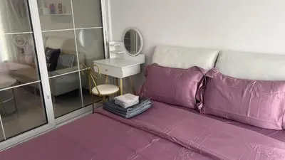a purple couch in a room with a mirror at GM bangson home in Bangkok