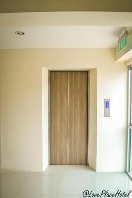 a wooden door in the middle of a building at Sixty Star Love Place Hotel in Bangkok