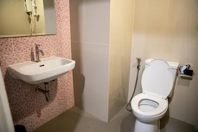 a bathroom with a toilet and a sink at Sixty Star Love Place Hotel in Bangkok